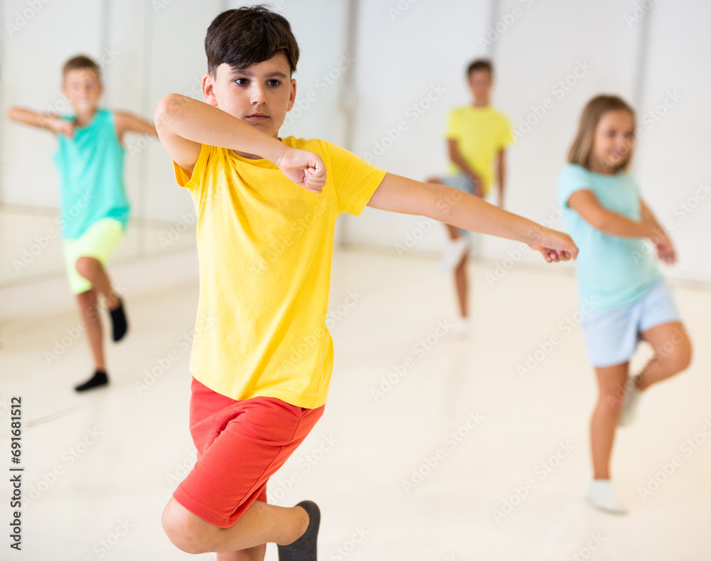 Group children learn dance movements in dance class