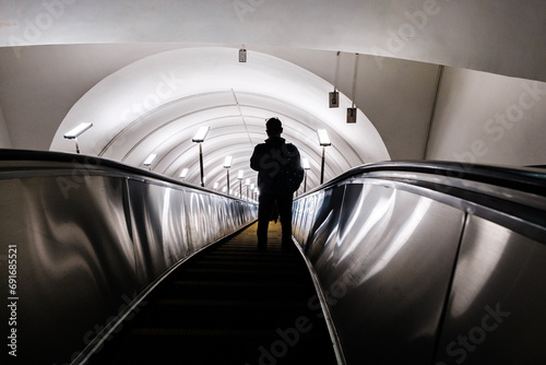 The silhouette of a man descending on an escalator in the subway (ID: 691685521)