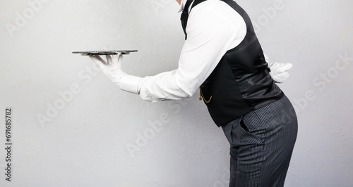 Portrait of Butler or Waiter in White Gloves Holding Silver Serving Tray. Concept of Service Industry and Professional Courtesy.