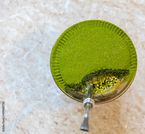 Traditional chimarrão prepared with yerba mate (Ilex paraguariesis) in a porongo gourd, isolated on a rustic wooden table photo