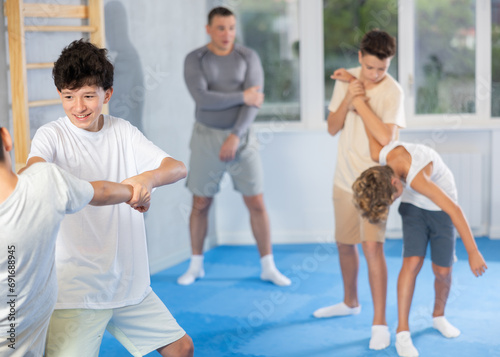 Kids sparring in self defense courses on tatami at modern sports studio