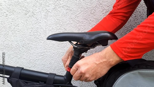 A short video of the bicycle trekking and the hands unlocking and lowering the bicycle seat.