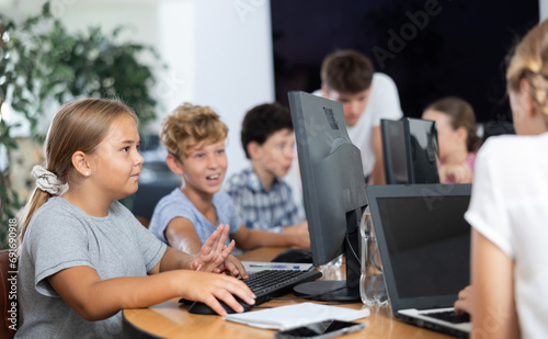 Computer science lesson in a school computer class - a girl and a boy solve problems on the computer together