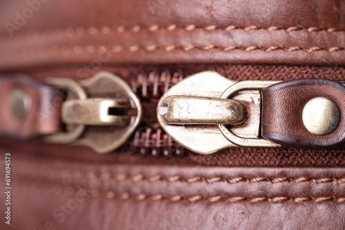 Zipper on a brown leather bag. Textured leather, space for text.