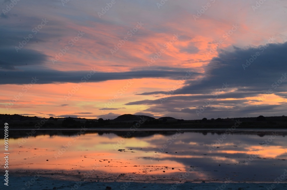 Atardecer de postal con cielos de color pastel reflejados en la laguna