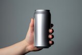Close up of a hand holding a can of soda on gray background 