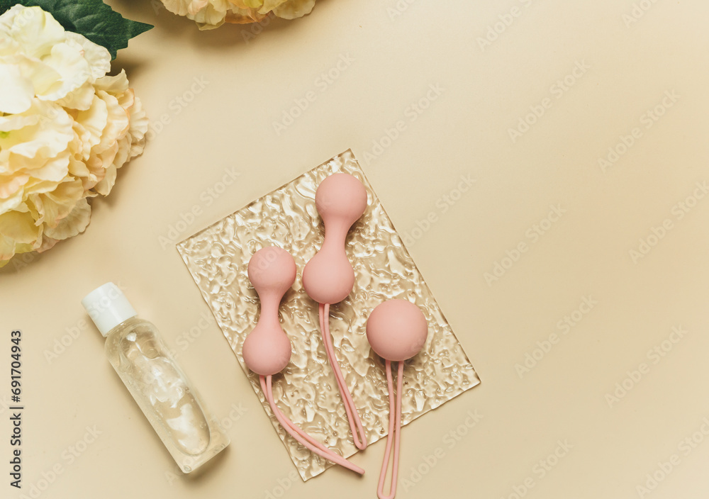 Pink balls and lubricant for special exercises for woman. Balls for intimate muscles of women. Kegel balls for strenthening the pelvic floor muscles, vaginal muscles. Mock up. Close up Pink balls and lubricant for special exercises for woman. Balls for intimate muscles of women. Kegel balls for strenthening the pelvic floor muscles, vaginal muscles. Mock up. Close up