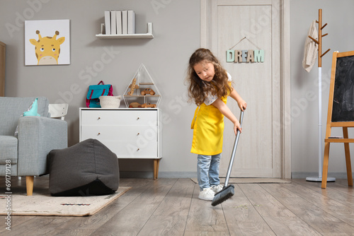 Cute little girl sweeping f...