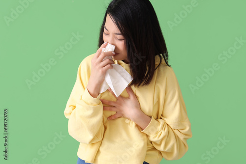Ill Asian woman with tissue...