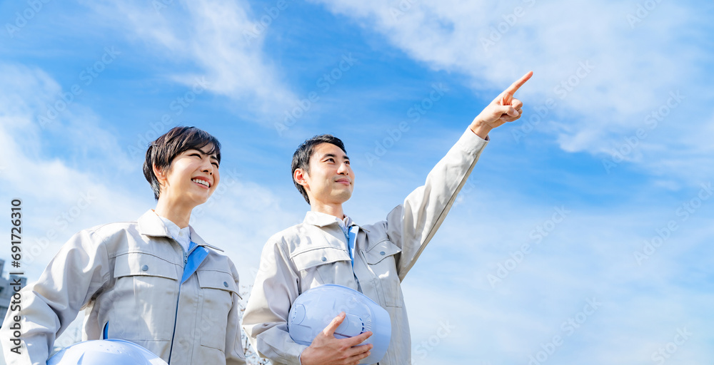 青空を指さすエンジニア　作業員　建設　産業