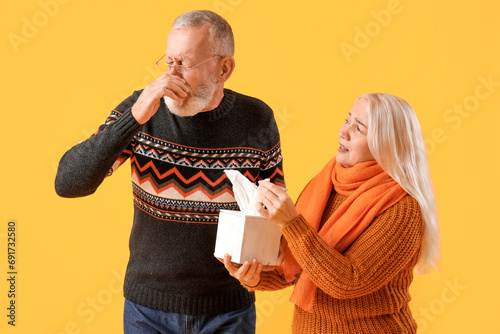 Sneezing mature man with ti...