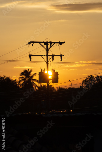 Silhouette of high voltage electricity pole with sunset sky background.