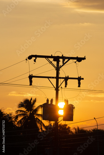 Silhouette of high voltage electricity pole with sunset sky background.