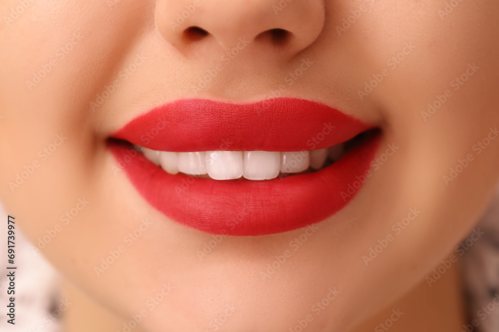 Fototapeta premium Beautiful smiling woman with red lipstick, closeup
