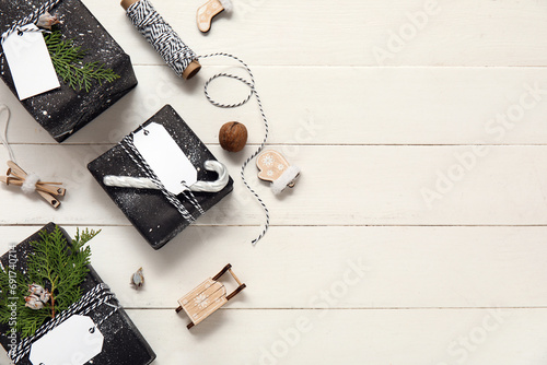 Composition with Christmas gifts, decorations and rope on white wooden background