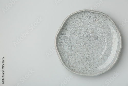 Beautiful ceramic plate on light gray background, top view. Space for text