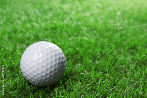 Golf ball on green grass, space for text