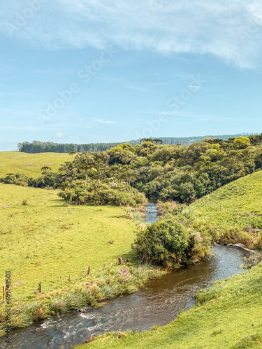 Beautiful green field landscape with mountains and clouds with blue sky and good weather conditions