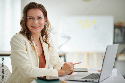 Portrait of happy confident mature entrepreneur working in office