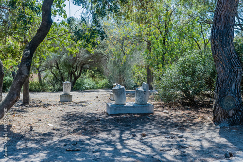Ancient stone urns on concrete plinths in garden part of the Agora ruins in Athens, Greece. photo