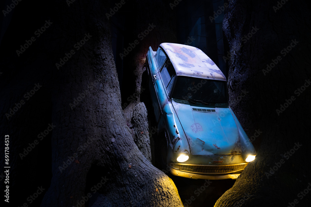 Fototapeta premium JAPAN - NOV 13, 2023: Blue Vintage Car 1960 Ford Anglia 105E flying and crashing into the forbidden forest at Warner Bros. Studio Tour Tokyo, The Making of Harry Potter, Wizarding World