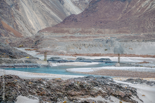 Far view of a hanging bridge over river. A Dried river trail of Shyok river in Nubra Valley in Ladakh Region of Indian Himalayan territory  photo