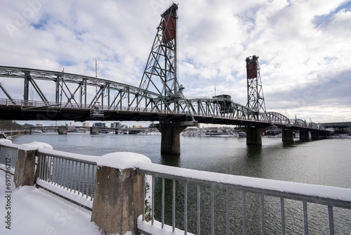 Hawthorne Bridge viewed from the west bank of the Willamette River in Portland, Oregon, after snowfall in winter. The truss bridge is the oldest vertical-lift bridge in operation in the United States. photo