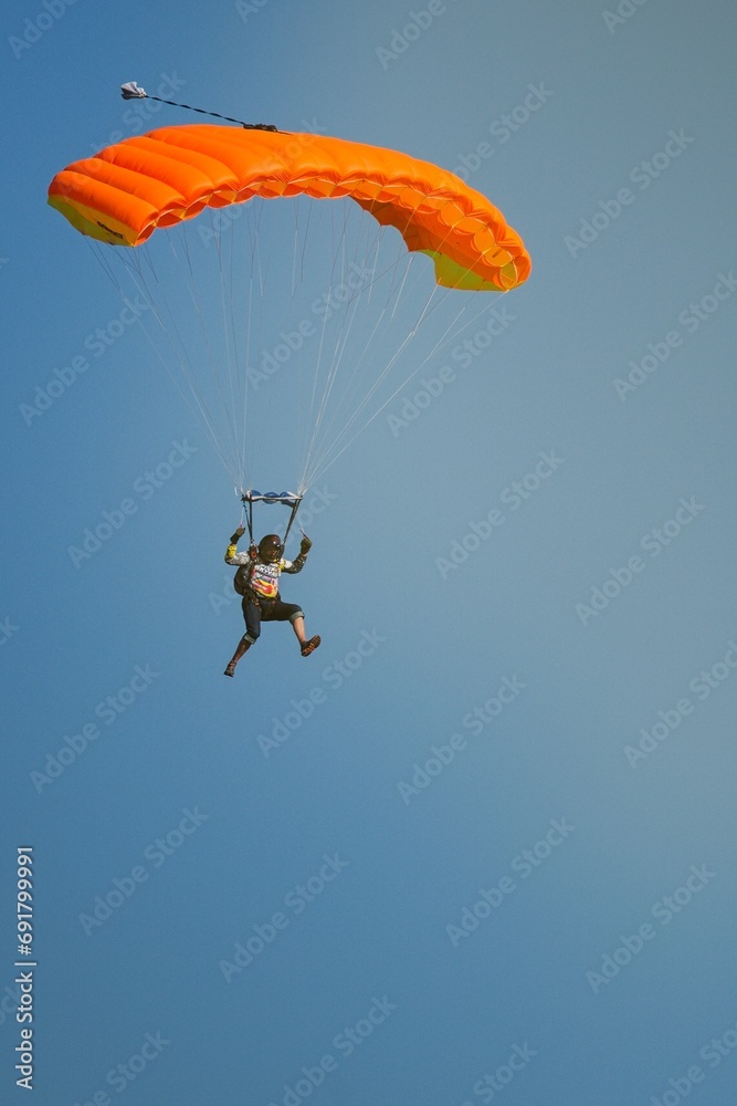 Two isolated skydiver with bright colorful parachute in the air during sunny day, Klatovy, Czechia Two isolated skydiver with bright colorful parachute in the air during sunny day, Klatovy, Czechia