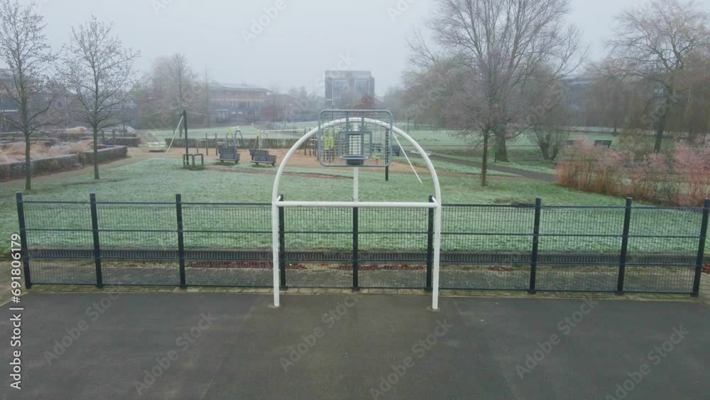 Dolly in of metal hoop of urban basketball court in a park on a cold and misty morning Dolly in of metal hoop of urban basketball court in a park on a cold and misty morning