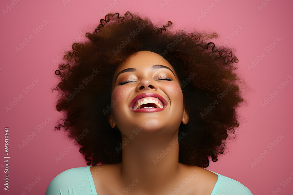 Happy laughing afro american woman with afro hairstyle in front of pink studio background Happy laughing afro american woman with afro hairstyle in front of pink studio background
