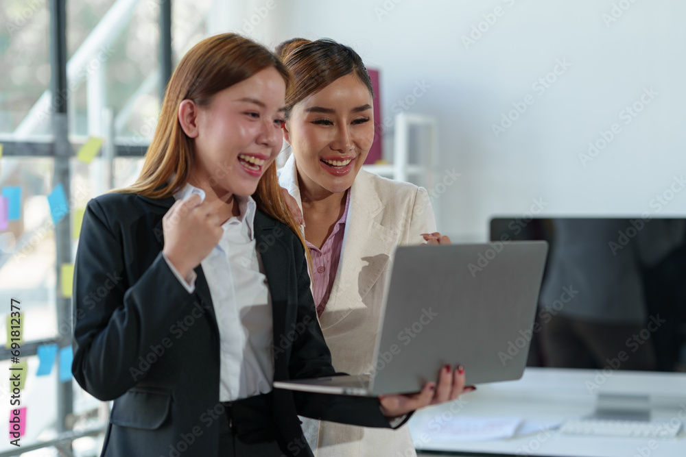 Two Asian businesswomen come up with an idea. Discuss investment projects and strategic planning with information via various documents and files. On a laptop computer at modern office. Two Asian businesswomen come up with an idea. Discuss investment projects and strategic planning with information via various documents and files. On a laptop computer at modern office.