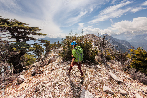 A girl with a backpack on a hike. adventure in the mountains. hiking with a backpack. girl with a backpack in the high mountains. Rock climbing and mountaineering concept.