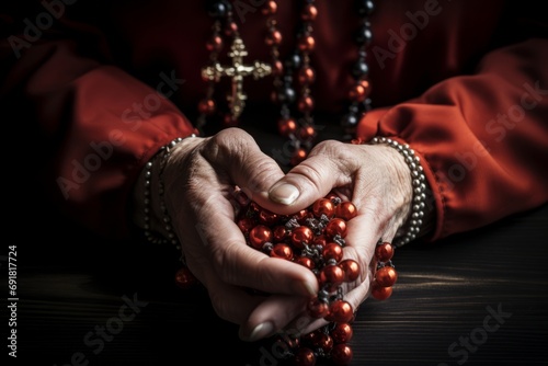 Hands engaged in prayer while holding a rosary