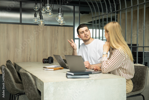 A young guy and a girl work on a laptop