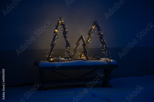 Three home made wooden Christmas trees with lights outside photo