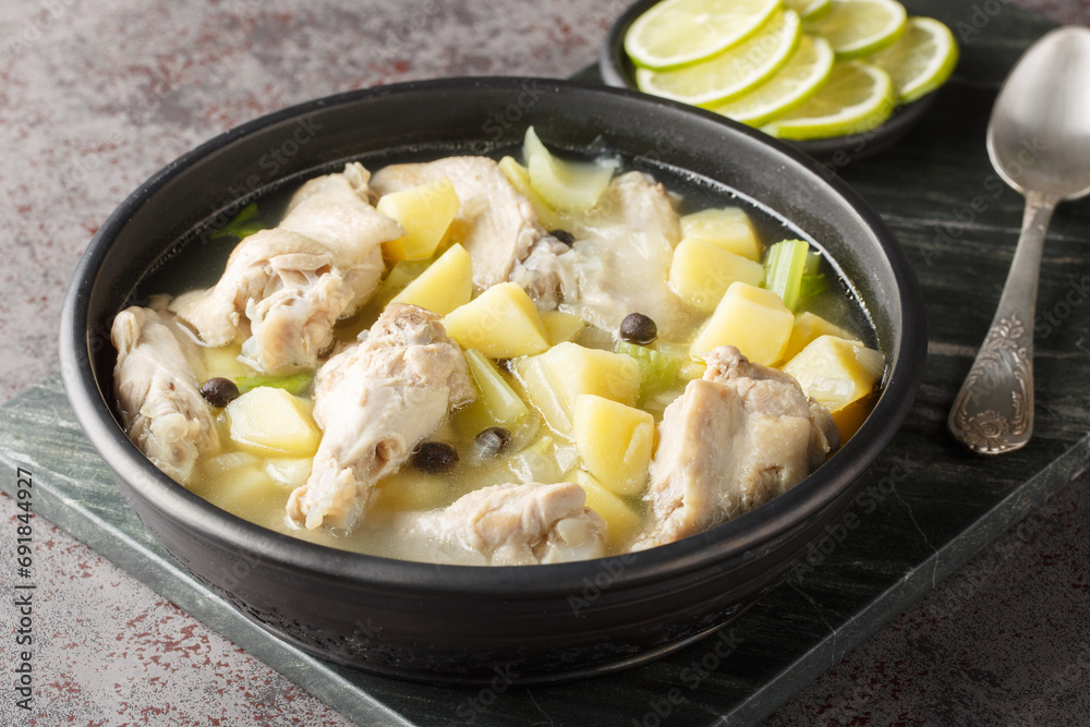 Chicken souse is a Bahamian soup consisting of clear broth where the meat and the vegetables are boiled down in the juice of fresh citrus closeup on the plate on the table. Horizontal Chicken souse is a Bahamian soup consisting of clear broth where the meat and the vegetables are boiled down in the juice of fresh citrus closeup on the plate on the table. Horizontal