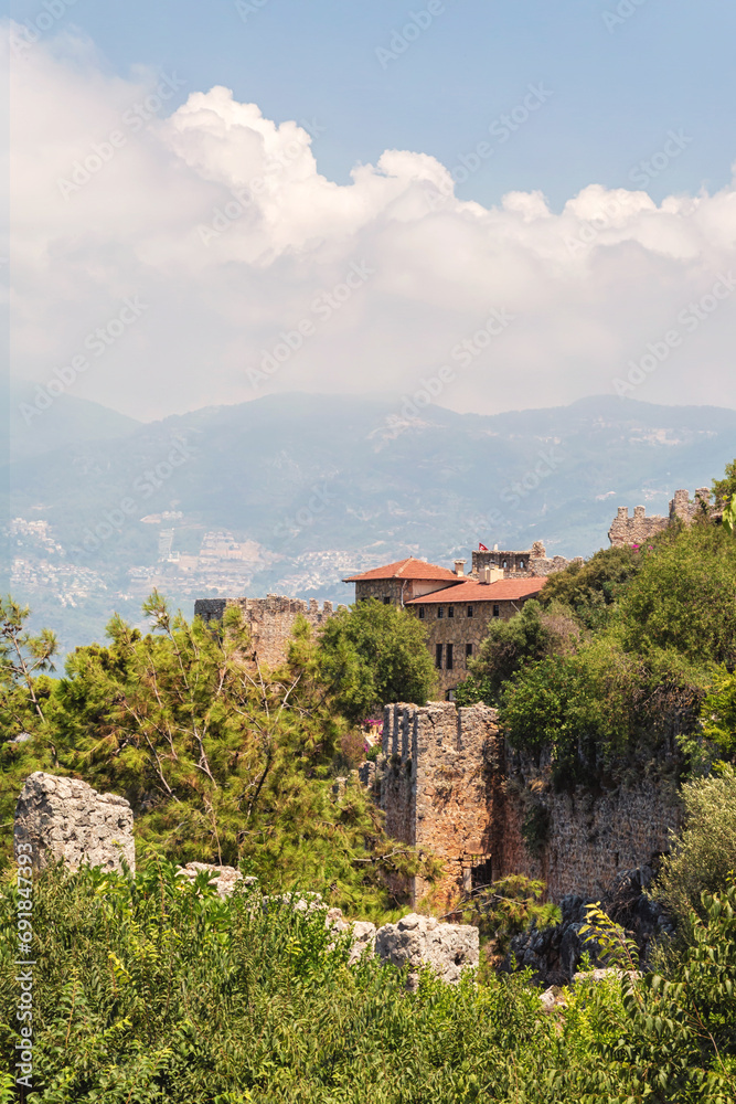 Obraz premium Scenic view of Alania. Houses and villas on the slopes of peninsula, the old part of city. Vertical shot. Alanya (Antalya region), Turkey (Turkiye)