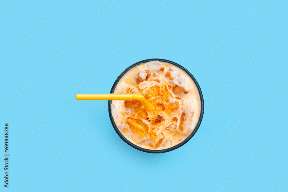 Ice Thai tea with milk on blue background. Ice Thai tea with milk on blue background.