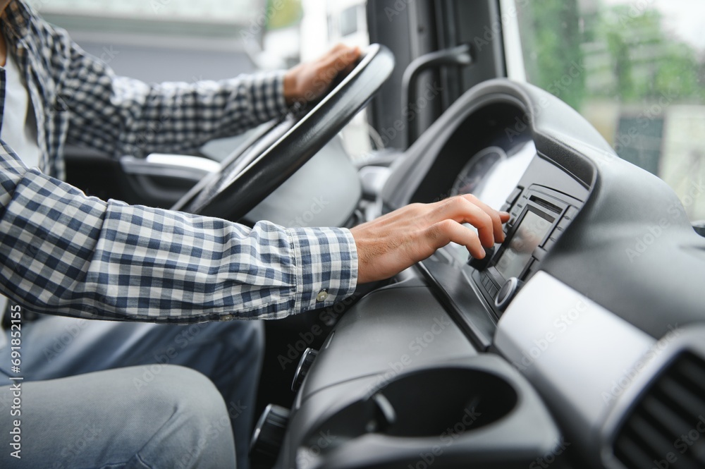 driver behind the wheel in truck cabin.