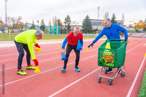 Mature friends placing training elements in an athletic track photo