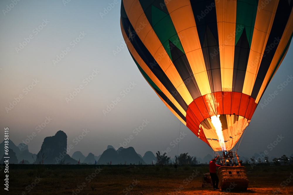 Scenic view of a hot air balloon at foggy sunrise in Yangshuo, China