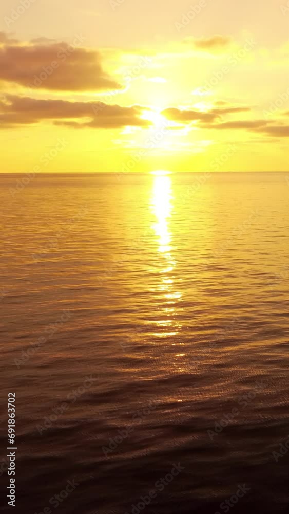 Sea water surface at sunset. Vertical aerial view, camera flies over calm golden sea. Sun glare. Abstract nautical summer ocean nature. Holiday and travel concept. Nobody. Weather and climate change Sea water surface at sunset. Vertical aerial view, camera flies over calm golden sea. Sun glare. Abstract nautical summer ocean nature. Holiday and travel concept. Nobody. Weather and climate change