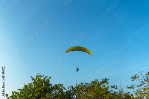 Paragliding in the sky over the sea. The concept of parachute flight. Tandem skydiver pilot and passenger fly on a sunny day.