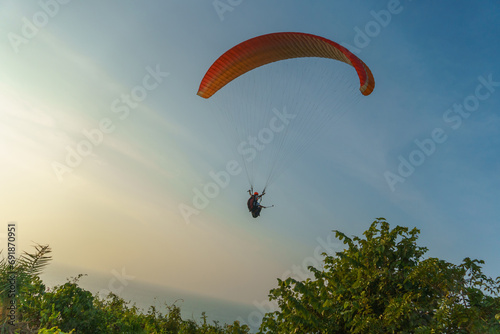 Paragliding in the sky over the sea. The concept of parachute flight. Tandem skydiver pilot and passenger fly on a sunny day.