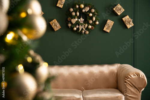 Gorgeous Christmas wreath on the wall, in a festive setting, surrounded by gifts and a Christmas tree, above a sofa photo