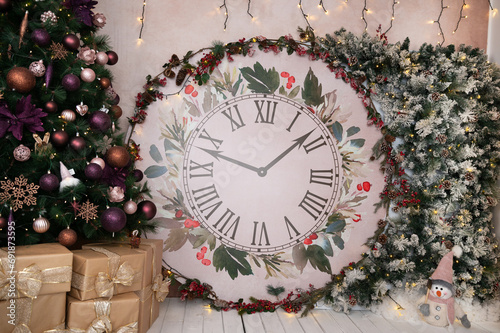 Gorgeous Christmas and New Year decor featuring Christmas clock decorated with snowy tree branches and other Christmas decorations: Christmas tree, snowman, gifts photo