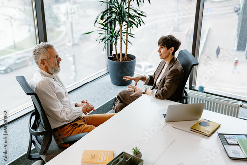 Portrait of professional man and woman sharing ideas during meeting in conference room