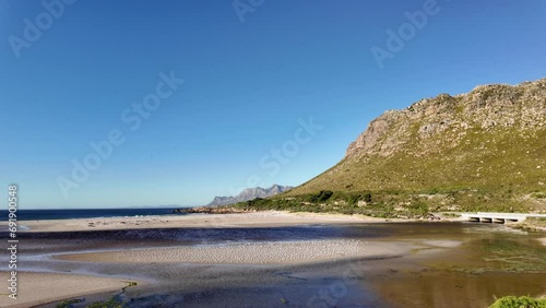View of the gorgeous Rooi Els beach and estuary with the Kogelberg Mountains and Clarence Drive in the background an a common tern (Sterna hirundo) colony on the sandbank. Western Cape. South Africa. photo