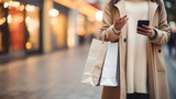 Mid section of woman using smart device with shopping bag in a blur bokeh city background