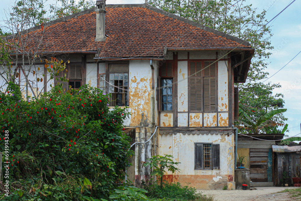 An old brick farm house building with a barn in the background, and flowers garden in Da Lat city Vietnam